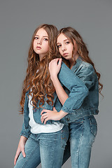 Image showing Full length of young slim female girl in denim jeans on gray background