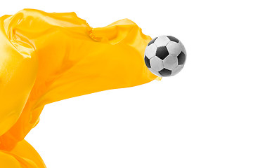 Image showing Soccer ball and Smooth elegant transparent yellow cloth isolated or separated on white studio background.