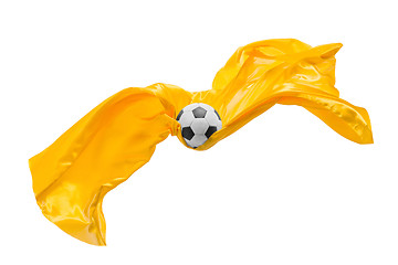 Image showing Soccer ball and Smooth elegant transparent yellow cloth isolated or separated on white studio background.