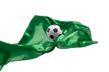 Image showing Soccer ball and Smooth elegant transparent green cloth isolated or separated on white studio background.