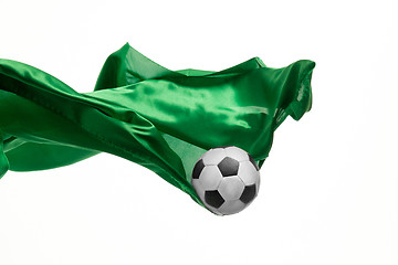 Image showing Soccer ball and Smooth elegant transparent green cloth isolated or separated on white studio background.