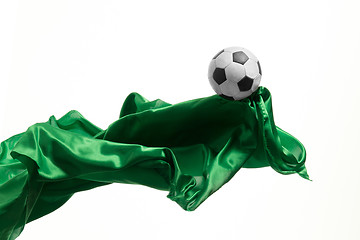 Image showing Soccer ball and Smooth elegant transparent green cloth isolated or separated on white studio background.