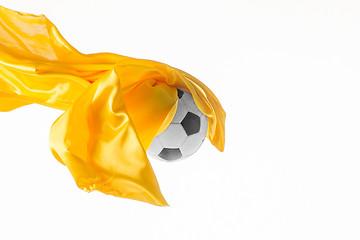 Image showing Soccer ball and Smooth elegant transparent yellow cloth isolated