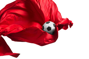 Image showing Soccer ball and Smooth elegant transparent red cloth isolated or separated on white studio background.