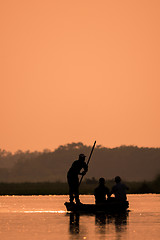 Image showing Men in a boat on a river silhouette