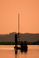 Image showing Men in a boat on a river silhouette