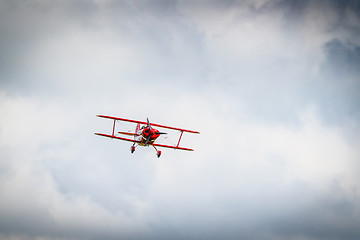 Image showing Red propeller airplane flying among the clouds