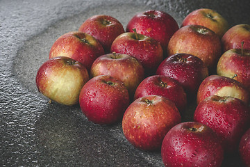 Image showing Wet apples on a granite rock in the rain