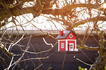 Image showing Red birdhouse barn hanging in a tree