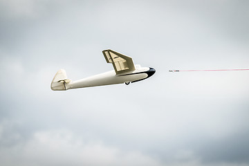 Image showing Small glider airplane with a line