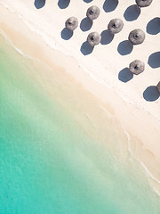 Image showing Aerial view of amazing tropical white sandy beach with palm leaves umbrellas and turquoise sea.