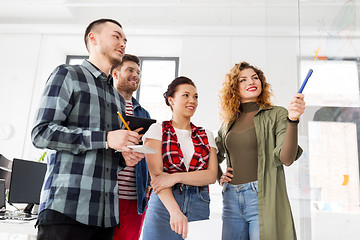 Image showing creative team with chart on glass board at office