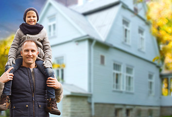 Image showing happy father and son over living house in autumn