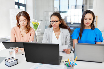 Image showing businesswomen with tablet pc and laptops at office