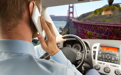 Image showing businessman calling on smartphone and driving car