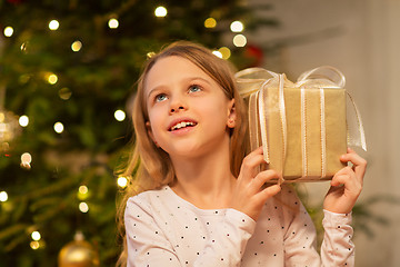 Image showing smiling girl with christmas gift at home