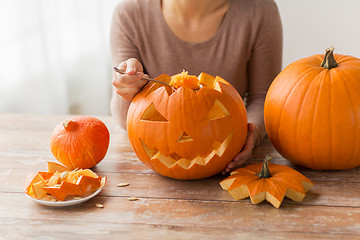 Image showing close up of woman carving halloween pumpkin