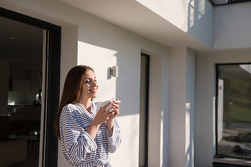 Image showing woman in a bathrobe enjoying morning coffee