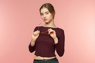 Image showing Woman standing and very cute looking at camera on the pink studio background