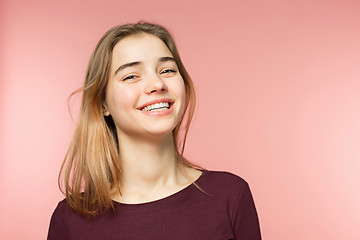 Image showing Woman smiling with perfect smile and white teeth on the pink studio background and looking at camera