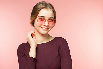 Image showing Woman smiling with perfect smile and white teeth on the pink studio background and looking at camera