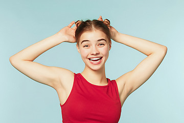 Image showing Woman smiling with perfect smile on the blue studio background