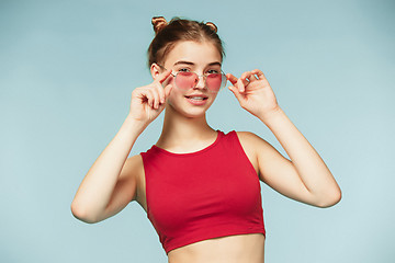 Image showing Woman standing and very cute looking at camera on the blue studio background