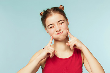 Image showing Woman smiling with perfect smile on the blue studio background