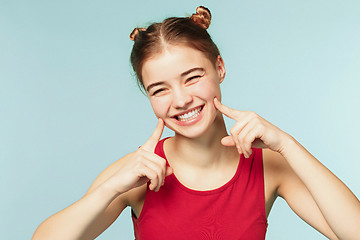 Image showing Woman smiling with perfect smile on the blue studio background