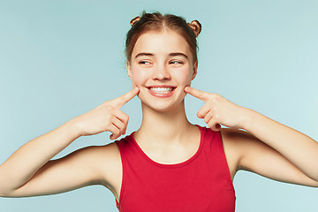 Image showing Woman smiling with perfect smile on the blue studio background