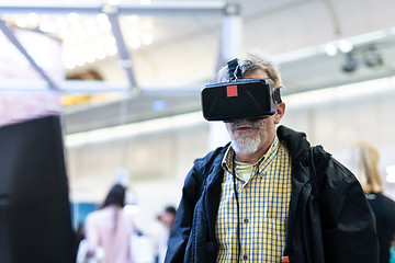 Image showing Senior man wearing virtual reality goggles watching virtual reality presentation.