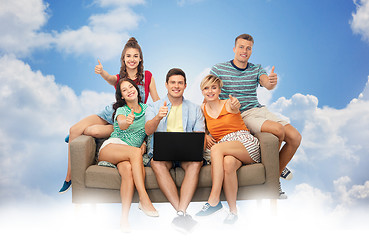 Image showing friends with laptop sit on sofa and show thumbs up