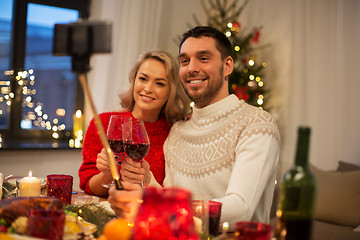 Image showing couple taking picture by selfie stick at christmas