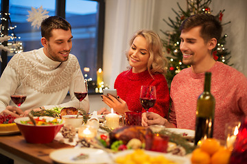 Image showing friends with cellphone celebrate christmas at home