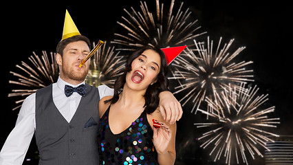 Image showing happy couple with party blowers having fun