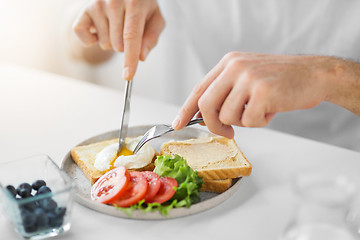 Image showing close up of man having toasts for breakfast