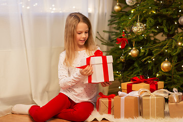 Image showing smiling girl with christmas gift at home