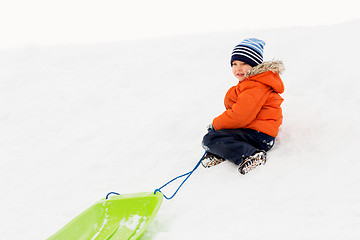 Image showing happy boy with sled on snow hill in winter