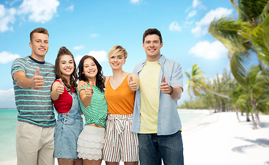 Image showing friends showing thumbs up over tropical beach