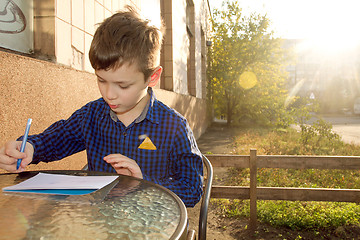 Image showing Boy doing homework outdoors