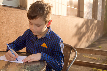 Image showing Boy doing homework outdoors