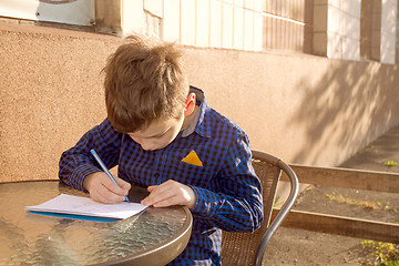 Image showing Boy doing homework outdoors