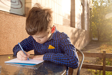 Image showing Boy doing homework outdoors