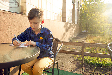 Image showing Boy doing homework outdoors