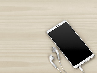 Image showing White smartphone and earphones on wood background