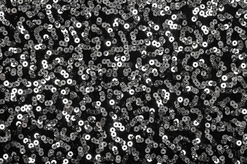 Image showing Shiny silver sequins on black background