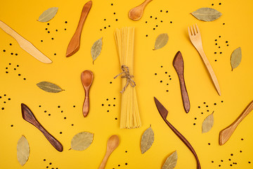 Image showing Wooden utensils, pasta and spices flat lay composition