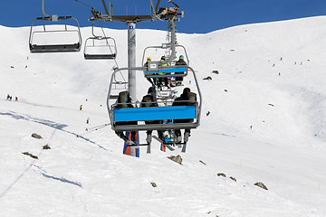 Image showing Skiers and snowboarders on chair-lift