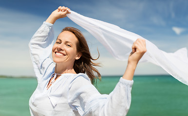 Image showing happy woman with shawl waving in wind on beach