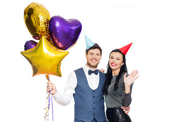 Image showing happy couple with party caps and balloons